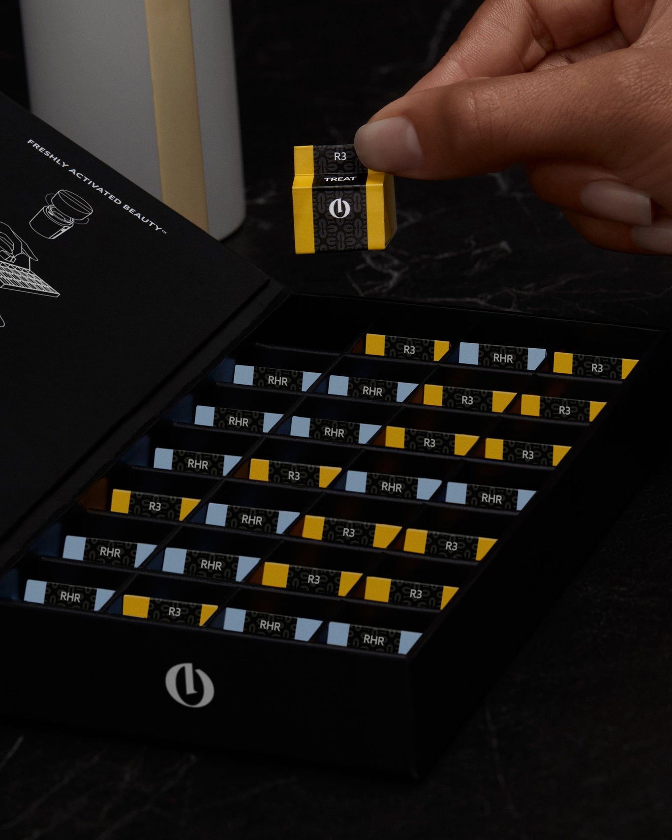 Hand pulls individual Opoule™ Treatment sleeve out of black packaging